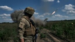 FILE - Seorang tentara Ukraina menyaksikan sistem peluncuran roket ganda Grad menembakkan peluru di dekat Bakhmut, wilayah Donetsk, Ukraina, 13 Agustus 2023.