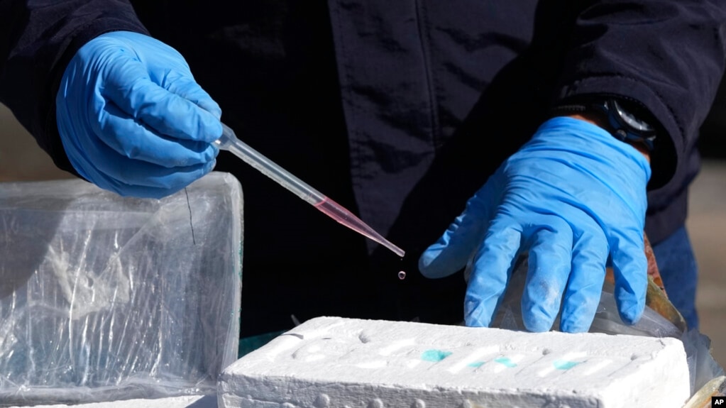 Un oficial antinarcóticos realiza un análisis químico para confirmar la pureza de un bloque de cocaína, en Cayambe, Ecuador, el viernes 3 de marzo de 2023.