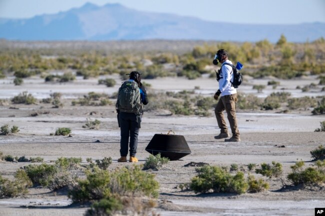 In this NASA photo, members of a recovery team from Lockheed Martin prepare to transport the asteroid sample, which touched down at the Department of Defense's Utah Test and Training Range on Sunday, Sept. 24, 2023. (Keegan Barber/NASA via AP)