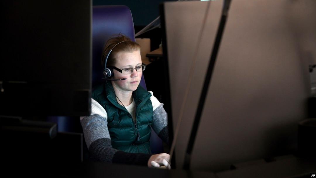 FILE - A 911 dispatch trainee works at a computer in Denver, Oct. 20, 2022. The city's STAR program uses clinicians and EMTs or paramedics to respond to nonviolent mental health crises, instead of police. 