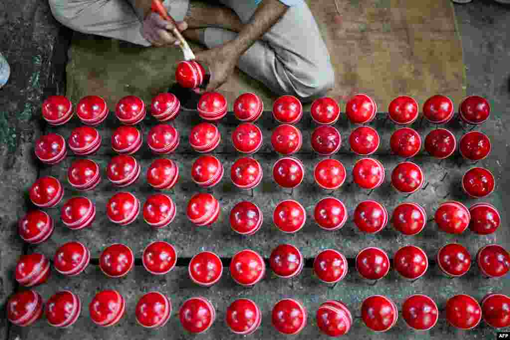 A worker polishes cricket balls at a workshop in Meerut in India&#39;s northern state of Uttar Pradesh, Sept. 14, 2023. &nbsp;(Photo by Money SHARMA / AFP)