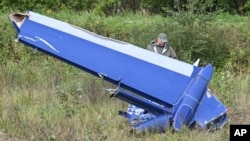 A serviceman inspects part of a crashed private jet near Kuzhenkino, Russia, on Aug. 24, 2023. Russian mercenary leader Yevgeny Prigozhin, founder of the Wagner Group, reportedly died when a private jet he was said to be on crashed on Aug. 23, 2023.