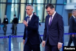 NATO Secretary-General Jens Stoltenberg and Ukrainian Foreign Minister Dmytro Kuleba walk during the NATO foreign ministers' meeting at the alliance's headquarters in Brussels, Apr. 4, 2023.