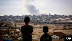 Anak laki-laki menyaksikan kepulan asap di tengah serangan Israel di timur Rafah di Jalur Gaza selatan pada 13 Mei 2024. (Foto: AFP)