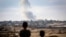 Boys watch smoke billowing during Israeli strikes east of Rafah in the southern Gaza Strip on May 13, 2024.