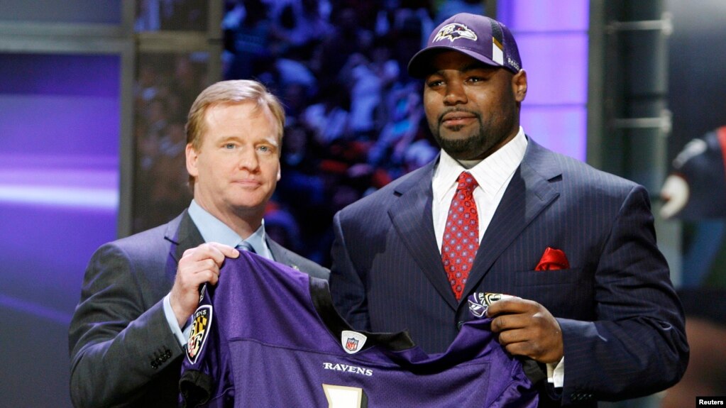 Pemain American Football Michael Oher (kanan) berpose setelah terpilih sebagai pemain Baltimore Ravens untuk musim 2009 dalam sebuah acara di New York, pada 25 April 2009. (Foto: Reuters/Ray Stubblebine)