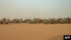 FILE — Vehicles of the Rapid Support Forces (RSF) paramilitaries await before leaving following a rally for supporters of Sudan's ruling Transitional Military Council (TMC) in the village of Abraq, June 22, 2019.