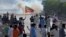 FILE - Supporters of Pakistan's former Prime Minister Imran Khan block a road as police fire tear gas to disperse them during a protest in support of Khan in Karachi, Pakistan, May 9, 2023. 