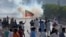 FILE - Supporters of Pakistan's former prime minister Imran Khan block a road as police fire tear gas to disperse them during a protest in support of Khan in Karachi, Pakistan, May 9, 2023. 