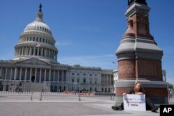 Jennifer Gay, a TikTok content creator, sits outside the U.S. Capitol, April 23, 2024, in Washington as senators prepare to consider legislation to force TikTok's China-based parent company to sell the social media platform under the threat of a ban.