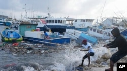 Nelayan menarik perahu yang rusak akibat Badai Beryl kembali ke dermaga di Bridgetown Fisheries di Barbados, Senin, 1 Juli 2024. (AP Photo/Ricardo Mazalan)