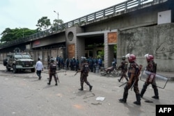 Police stand guard at the headquarters of state broadcaster Bangladesh Television, after students set it on fire amid the ongoing anti-quota protest in Dhaka, July 19, 2024.