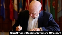 In this photo provided by the Montana Governor's Office, Republican Gov. Greg Gianforte signs a law banning TikTok in the state, Wednesday, May 17, 2023, in Helena, Mont. That law made Montana became the first state in the U.S. to completely ban TikTok.