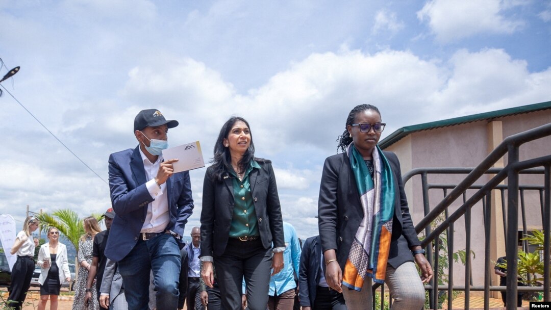 FILE - British Home Secretary Suella Braverman walks with Paul Rwigamba, director of Projects and Property Management and Flora Uwayezu, Project Sales of the Century Real Estate group during a tour in Kigali Rwanda, March 18, 2023. 