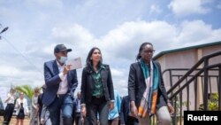 FILE - British Home Secretary Suella Braverman walks with Paul Rwigamba, director of Projects and Property Management and Flora Uwayezu, Project Sales of the Century Real Estate group during a tour in Kigali Rwanda, March 18, 2023. 