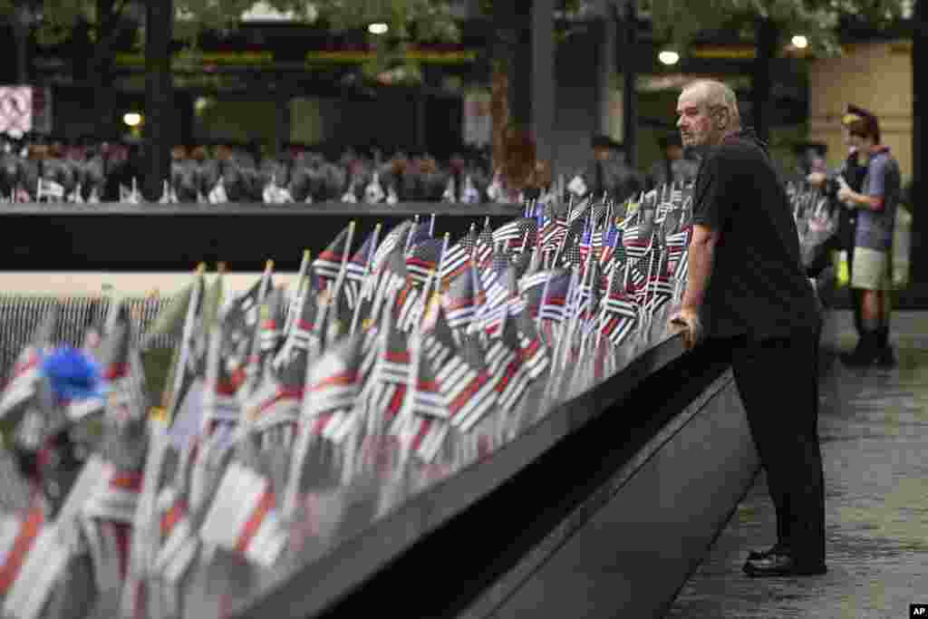 Una persona observa las banderas antes de la ceremonia conmemorativa de los ataques terroristas del 11 de septiembre de 2001, el lunes 11 de septiembre de 2023, en Nueva York.