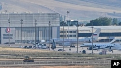 A Russian plane, rear center, believed to be carrying released Russian prisoners, is seen at Ankara Airport, Turkey, Aug. 1, 2024.