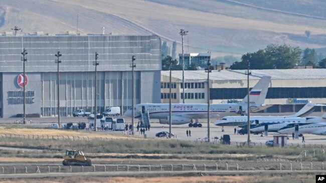 A Russian plane, rear center, believed to be carrying released Russian prisoners, is seen at Ankara Airport, Turkey, Aug. 1, 2024.