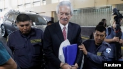 ARCHIVO - El periodista guatemalteco José Rubén Zamora es escoltado por la policía después de haber sido sentenciado en un tribunal de Ciudad de Guatemala el 14 de junio de 2023.