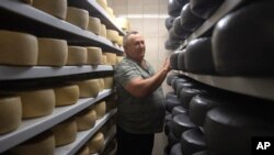 Victor Tsvyk, an owner of a private farm, inspects a goat cheese storage in Zhurivka, Kyiv region, Ukraine, Aug. 10, 2023.