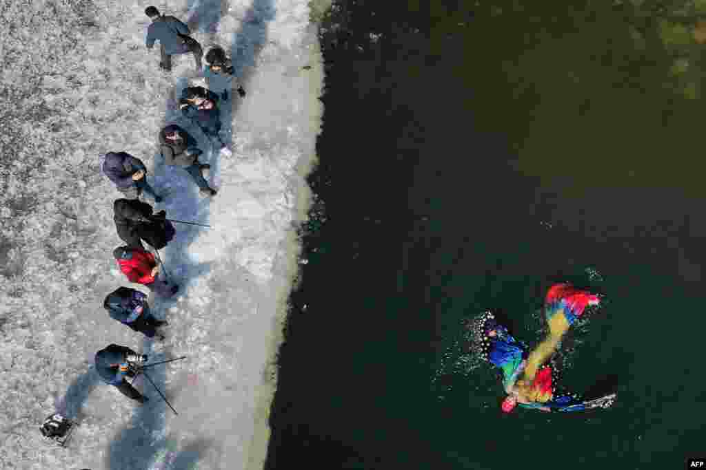 A woman dressed in a mermaid swims in a partly frozen lake in Shenyang, in northeastern China&#39;s Liaoning province.