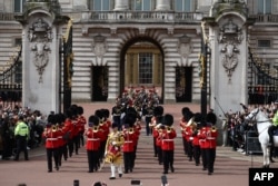 Members of France's Gendarmerie Garde Republicaine march behind members of the British Army's Band of the Grenadier Guards after taking part in a special Changing of the Guard ceremony at Buckingham Palace in London, April 8, 2024.