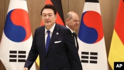 German Chancellor Olaf Scholz, rear, and South Korea's President Yoon Suk Yeol arrive for their meeting at the Presidential Office in Seoul, South Korea, May 21, 2023. Scholz arrived in Seoul after attending the G7 summit in Hiroshima, Japan.