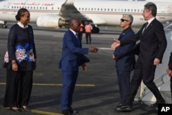 Ivory Coast's Minister of Foreign Affairs Kacou Houadja Leon Adom, center, welcomes U.S. Secretary of State Antony Blinken, right, at the Felix Houphouet-Boigny International Airport in Abidjan, Ivory Coast, Jan. 22, 2024.