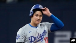 FILE - Los Angeles Dodgers designated hitter Shohei Ohtani takes his helmet off in a game against the San Diego Padres at the Gocheok Sky Dome in Seoul, South Korea, March 20, 2024.