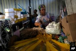 Barbara Rigaud, president of Turma da Paz de Madureira samba school, arranges costumes on Feb. 4, 2023. (AP Photo/Silvia Izquierdo)