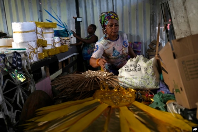 Barbara Rigaud, president of Turma da Paz de Madureira samba school, arranges costumes on Feb. 4, 2023. (AP Photo/Silvia Izquierdo)