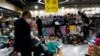 FILE - Customers shop at a shoe store during a clearance sale at a mall in Beijing, China, Jan. 15, 2023.
