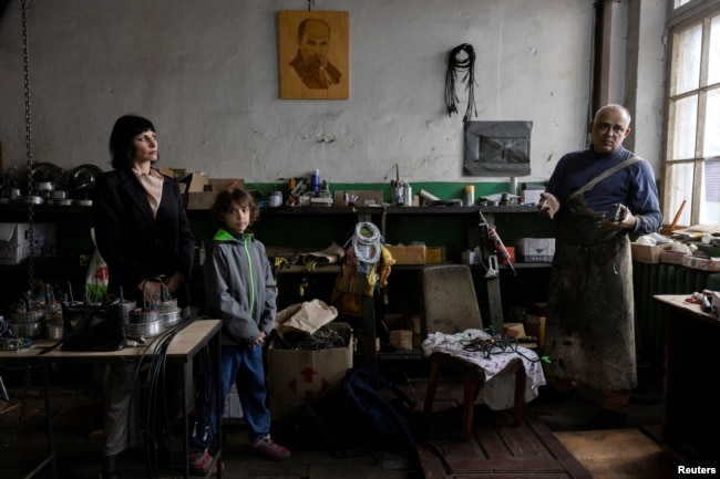 Dmytro Mamonov, his wife Oksana and daughter Yesenia stand in their workshop, May 31, 2024. (REUTERS/Thomas Peter)