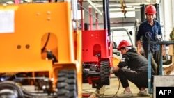 中国山东省青州一个铲车厂的工人正在生产铲车。（2023年10月27日）