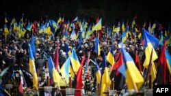 People take part in the funeral ceremony of Ukrainian servicemen Myroslav Stets, Anatoliy Pylypenko and Vladyslav Vyshatytskyi, killed in action, at the Lychakiv cemetery in Lviv, March 7, 2023. 