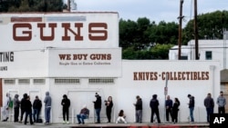 FILE – People wait to enter a gun store in Culver City, Calif., on March 15, 2020. 