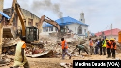 Masu aikin ceto na tono mutane daga wani gini da ya rushe a Abuja, Najeriya