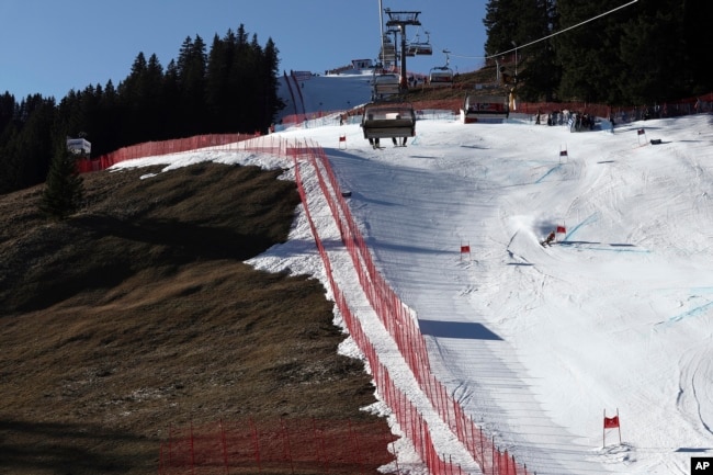 FILE - An athlete speeds down the course during an alpine ski, men's World Cup giant slalom race, in Adelboden, Switzerland, Jan. 7, 2023. Mother Nature and global warming are having just as much say about when and where to hold ski races these days as the International Ski Federation.