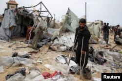 28일 이스라엘 군의 공습으로 파괴된 난민 텐트촌에 한 부상을 입은 남성이 목발을 짚고 있다.