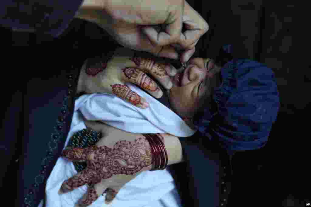 A health worker administers a polio vaccine to a child at a neighborhood of Lahore, Pakistan. (AP Photo/K.M. Chaudary)