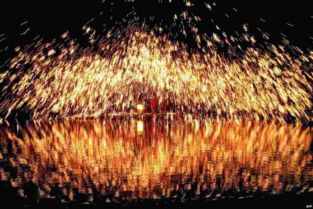 Percikan api yang disebabkan oleh besi cair terciprat selama Festival Lagu Zhuang, juga dikenal sebagai &quot;San Yue San&quot; yang dirayakan oleh etnis minoritas di Liuzhou, di wilayah Guangxi, China barat daya.