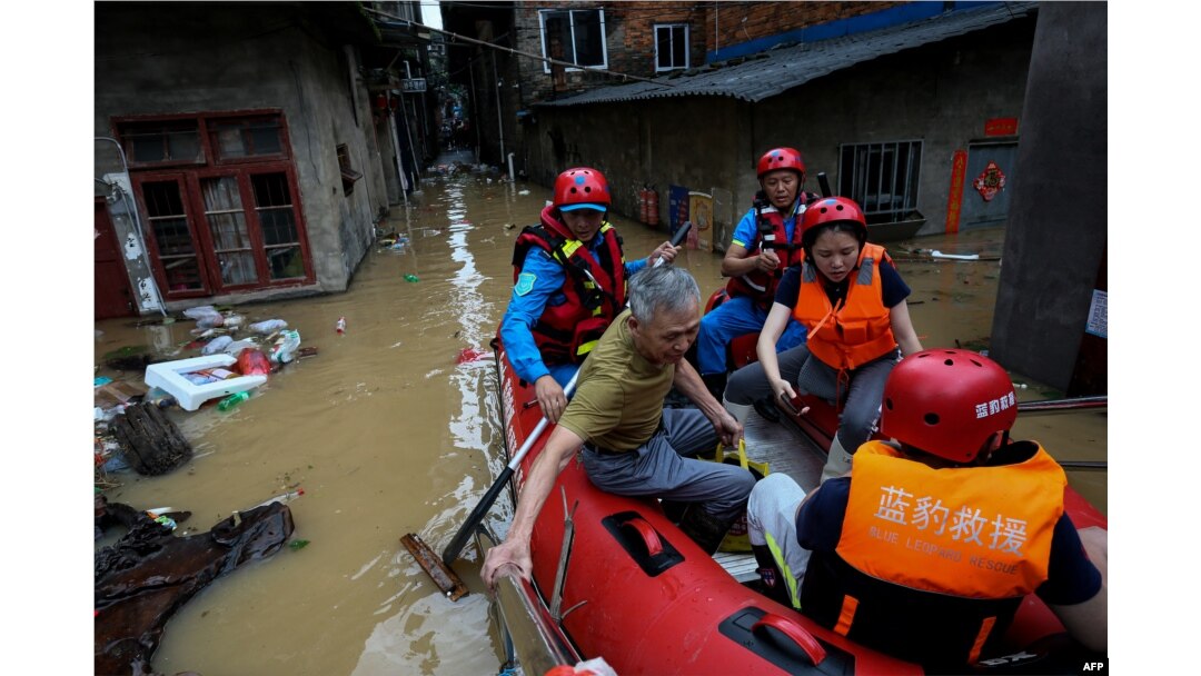 Seorang penduduk desa duduk di perahu karet bersama tim penyelamat di daerah banjir setelah badai di Nanping, provinsi Fujian, China timur, 16 Juni 2024. (CNS / AFP)