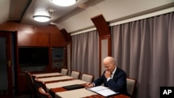 资料照片：2023年2月20日，拜登总统突访乌克兰在基辅与乌克兰总统泽连斯基见面后，在火车上审阅纪念乌克兰战争一周年的演讲稿。（美联社照片）