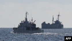 FILE - A Philippine coast guard vessel patrols near the grounded navy ship BRP Sierra Madre, April 23, 2023, where Philippine marines are stationed to assert Manila's claims at Second Thomas Shoal in the disputed South China Sea.