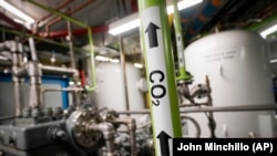 A liquid carbon dioxide pipe is labeled in a production room of The Grand Tier luxury apartment building, where the carbon byproduct of a natural gas fired water boiler is repurposed for industrial sale, Tuesday, April 18, 2023, in New York. (AP Photo/John Minchillo)