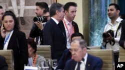 El secretario de Estado de EEUU, Antony Blinken, arriba al centro, pasa junto al ministro de Relaciones Exteriores de Rusia, Sergey Lavrov, durante la reunión de ministros de Relaciones Exteriores del G20 en Nueva Delhi el jueves 2 de marzo de 2023. 