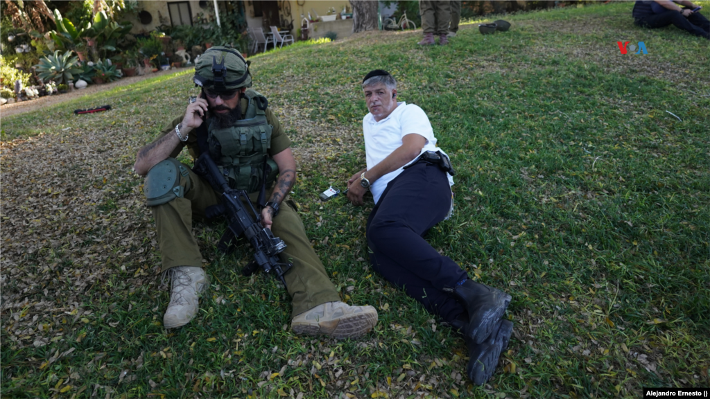 Un soldado israelí descansa en el césped del kibutz Holit durante un recorrido en busca de restos humanos y evidencias del ataque. 