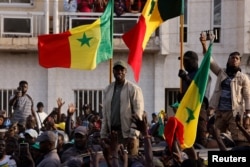 Senegalese opposition leader Ousmane Sonko greets his supporters as he arrives to attend the protest to demand the release of alleged political prisoners ahead of his court appearance on Thursday on libel charges, in Dakar, March 14, 2023.