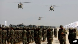 Beberapa helikopter UH-60 Black Hawk terbang selama parade militer untuk menandai ulang tahun ketiga penarikan pasukan pimpinan AS dari Afghanistan, di Pangkalan Udara Bagram di Provinsi Parwan, Afghanistan, 14 Agustus 2024.