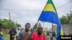 Les gens célèbrent en soutien aux putschistes dans une rue de Port-Gentil, Gabon, le 30 août 2023.